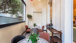 A cozy indoor seating area with a round table, chairs, and potted plants. - Canvas Boutique Hotel  (Beirut)