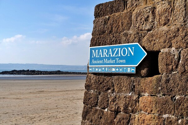Schild für Marazion, eine historische Markstadt, mit Symbolen für Einrichtungen wie Toilette, Verpflegung und Kirche.
