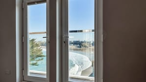 A window with a view of a beach and cityscape.