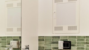 Une salle de bain avec un lavabo blanc, des toilettes et un miroir.