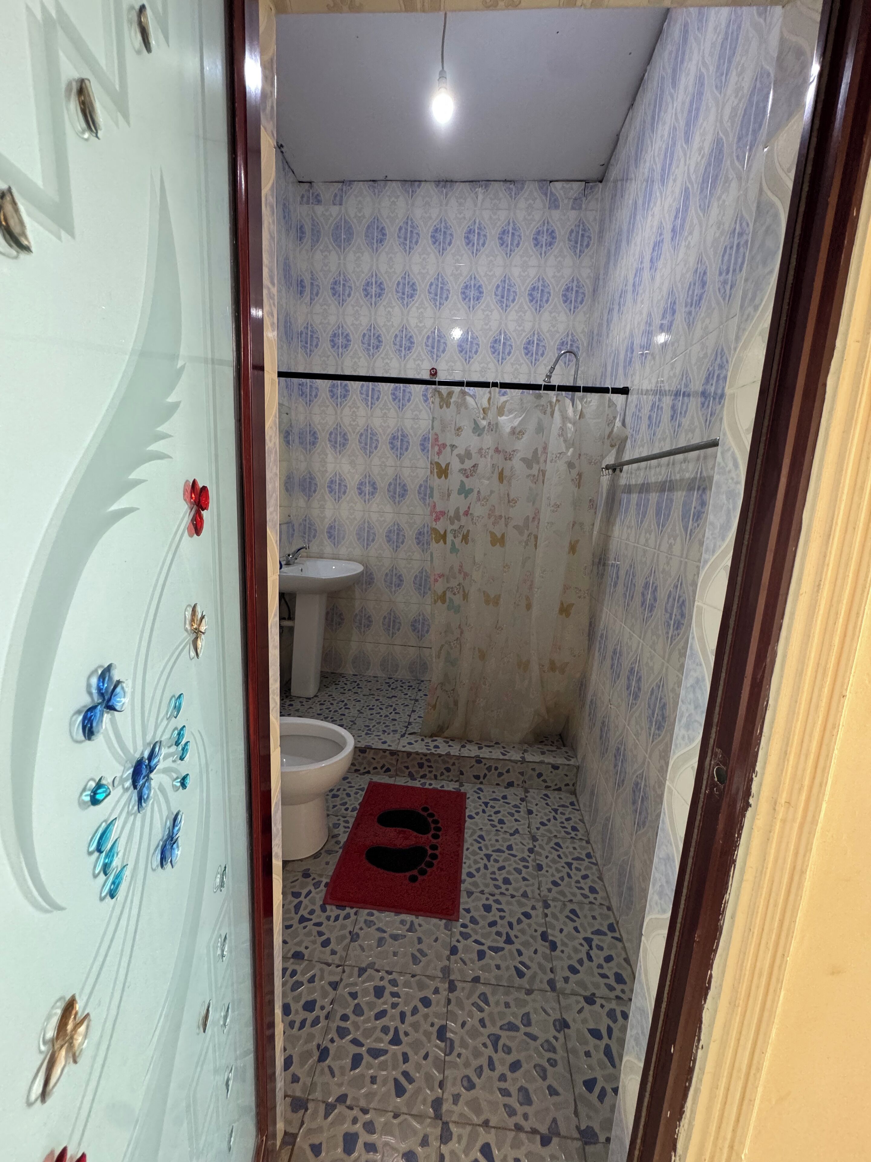 A bathroom with a toilet, sink, and shower area.