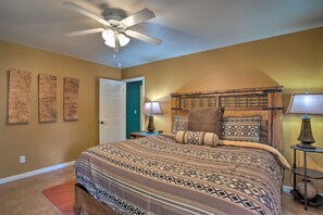 A bedroom with a bed, a ceiling fan, a door, and a nightstand with a lamp. - 3444 Views, Garage and backyard, Shared Pool and Hot Tub! (Moab)