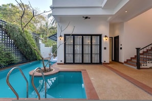 A modern house with a swimming pool, a staircase, and a large sliding glass door. - Lux 3BR Villa in Siolim 4km to Beach Wadi House (Siolim)