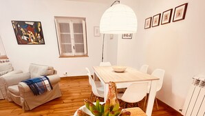 A dining area with a wooden table, white chairs, and a white bowl.