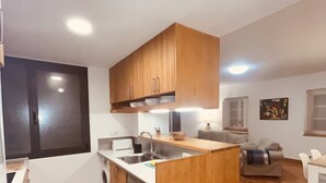 A compact kitchen with wooden cabinets, a built-in dishwasher, and a central island.