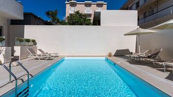 Piscina externa, guarda-sóis, espreguiçadeiras