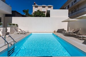 Utomhuspool, parasoller och solstolar