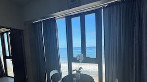 A room with a table and chairs, a view of the ocean, and a 'No Entry' sign on the wall. - BednBong Experience Stay (Arecibo)