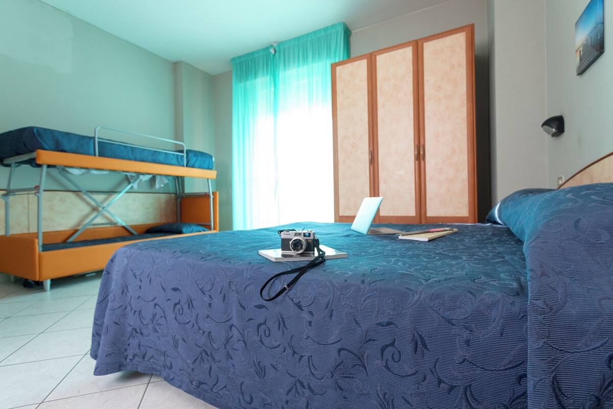 Un dormitorio con literas, un escritorio y un armario.