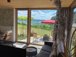 A modern living room with a large sliding glass door leading to an outdoor terrace. - MoselHoch vacation cottage in the vineyards of Klüsserath (Klüsserath)