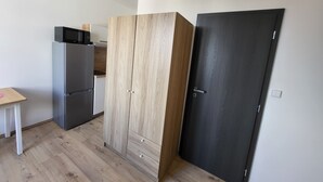 Una cocina moderna con microondas integrado, refrigerador y armario de madera.