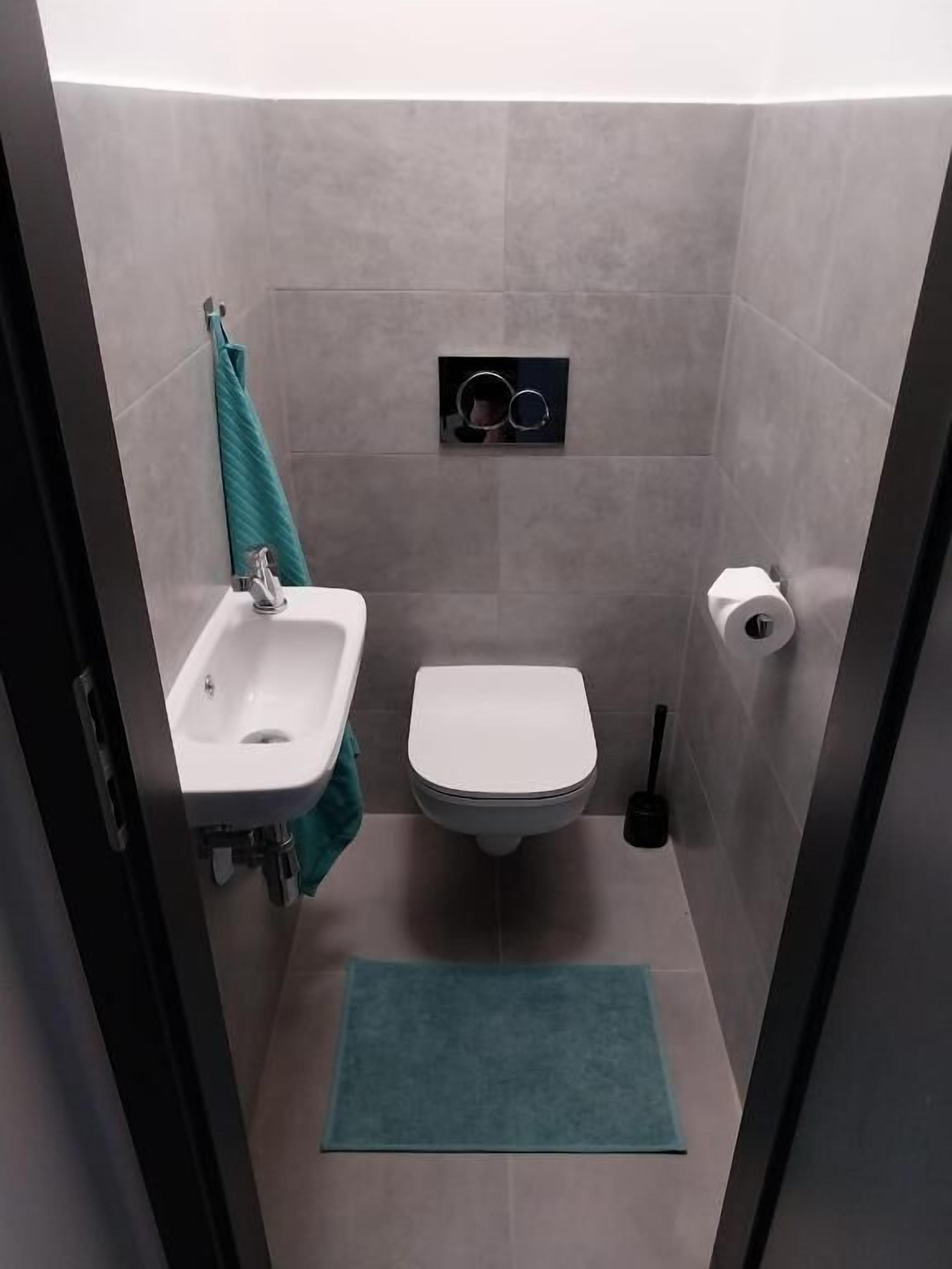Un baño pequeño con lavamanos, inodoro y espejo.