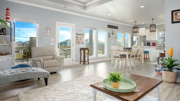 A spacious living area with a large window, a dining table, and a cozy seating arrangement. - Big Chill 2 Bedroom Home (Port Bolivar)