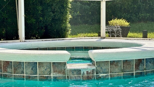 A swimming pool with a stone border and steps leading into the water. - Tranquilo Villa A Shine Villas Property In Tuscan Hills 5 Bedroom Villa (Davenport)