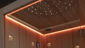 A wooden sauna with a bench and a bench with a storage box. - La Maison Coloniale Suites (The Indies Rose) and Wellness Zone. (Cagliari)