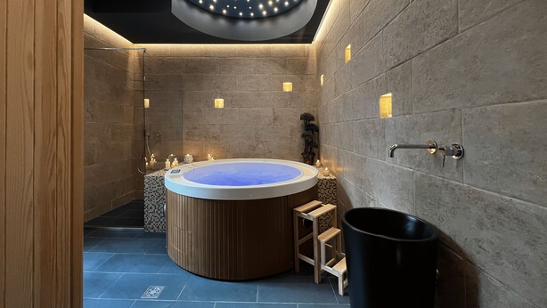 A modern bathroom with a freestanding bathtub, a wooden stool, and a black trash bin. - La Maison Coloniale Suites (The Indies Rose) and Wellness Zone. (Cagliari)