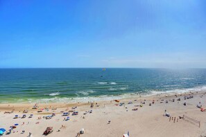Ein Strand mit Sonnenschirmen und Menschen.