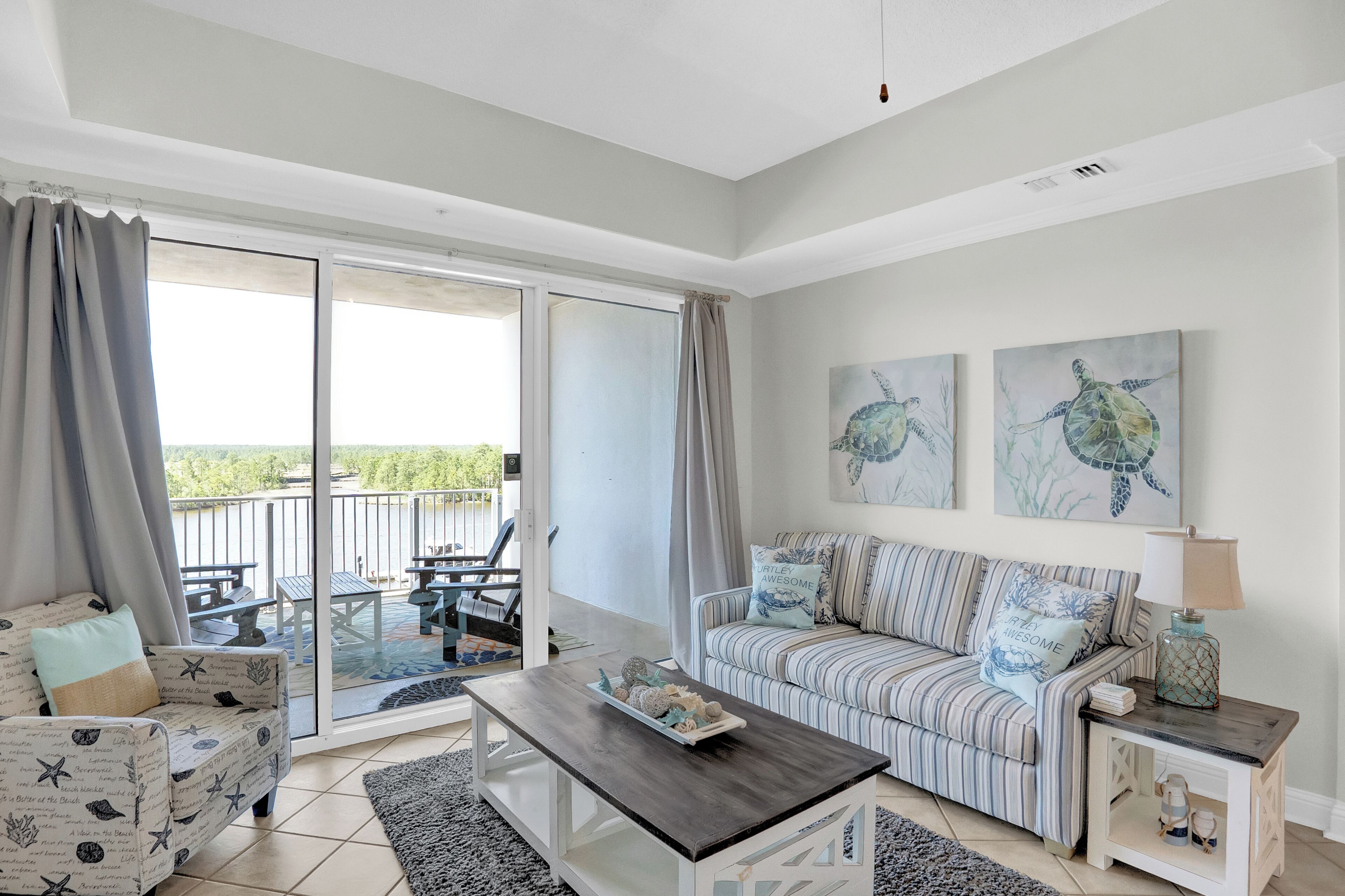 A spacious living area with a sofa, a coffee table, and a sliding glass door leading to an outdoor patio.