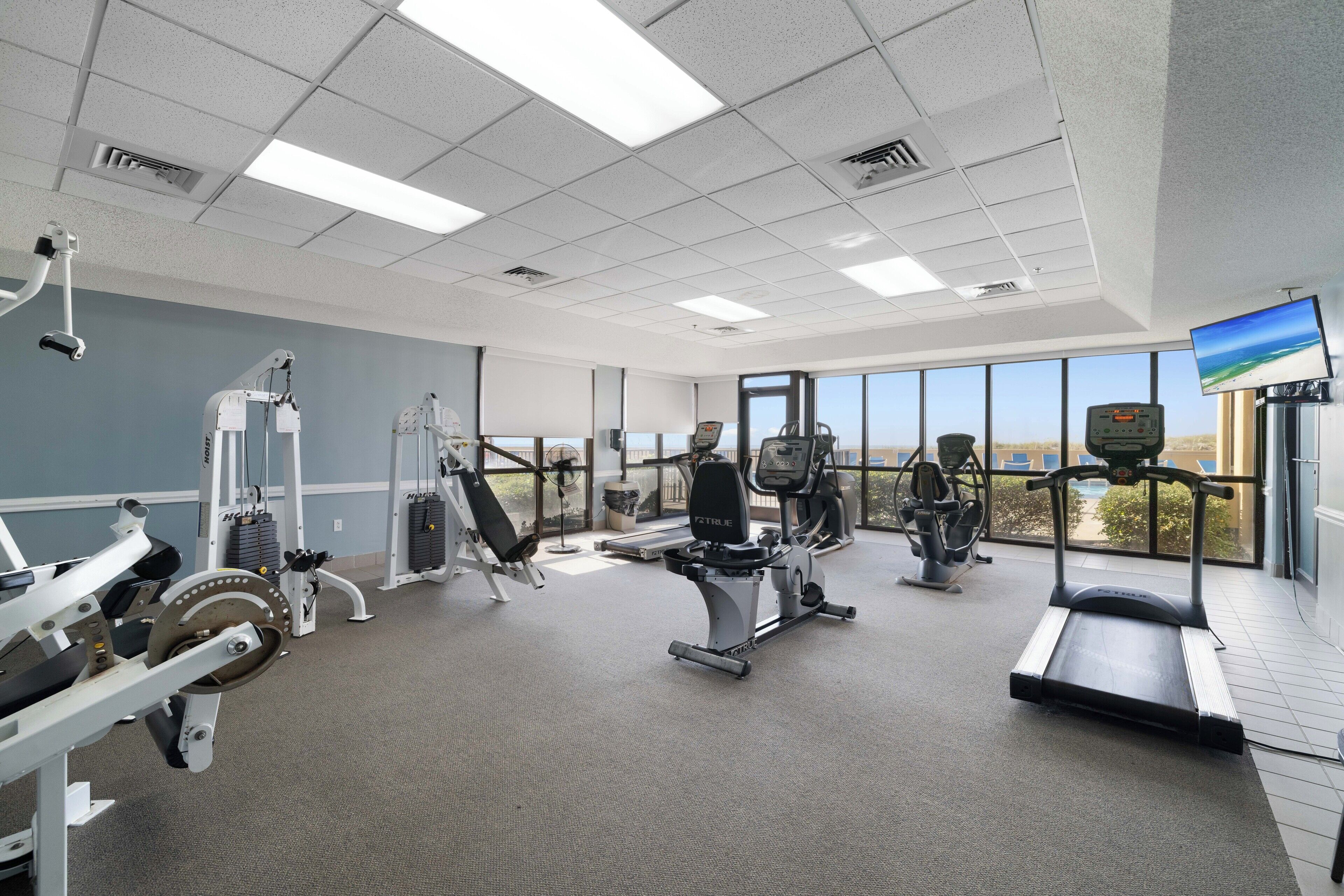 A gym with cardio machines, weight equipment, and a treadmill.