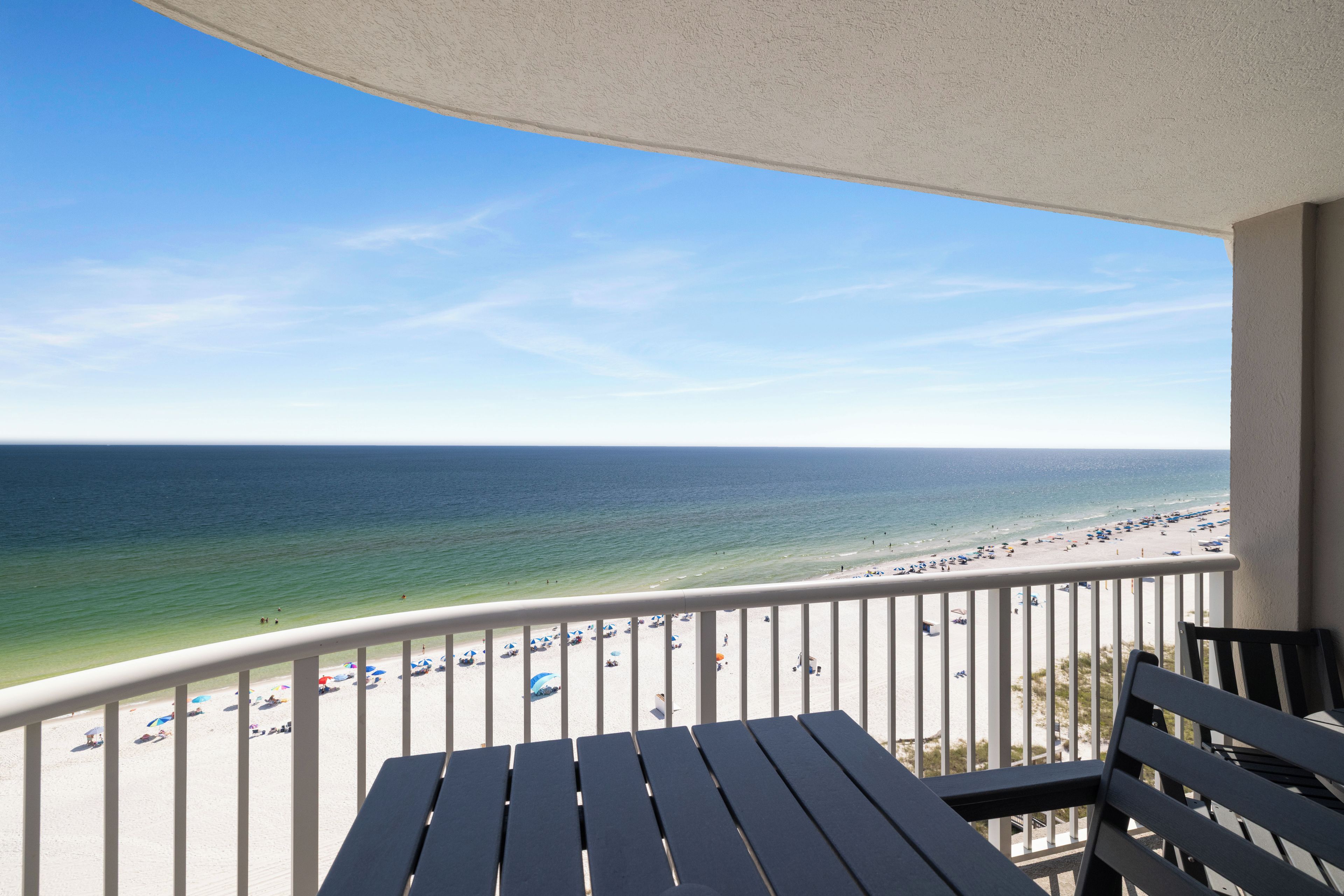 Ein Balkon mit Blick auf Strand und Meer.
