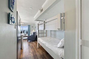A compact room with a bunk bed, a desk, and a chair.