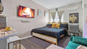 Une chambre d’hôtel avec un lit, un bureau, une chaise et un téléviseur.