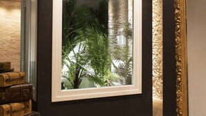A room with a large window, wooden floor, and a wall-mounted mirror. - La Maison Coloniale Suites (The Saigon Jade) and Wellness Zone (Cagliari)