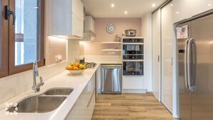 Eine moderne Küche mit Edelstahlgeräten, einer doppelten Spüle und Holzboden.
