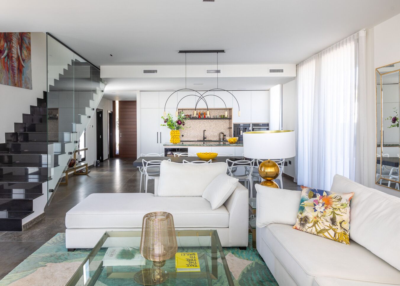 A modern living room with a sofa, coffee table, and a staircase.