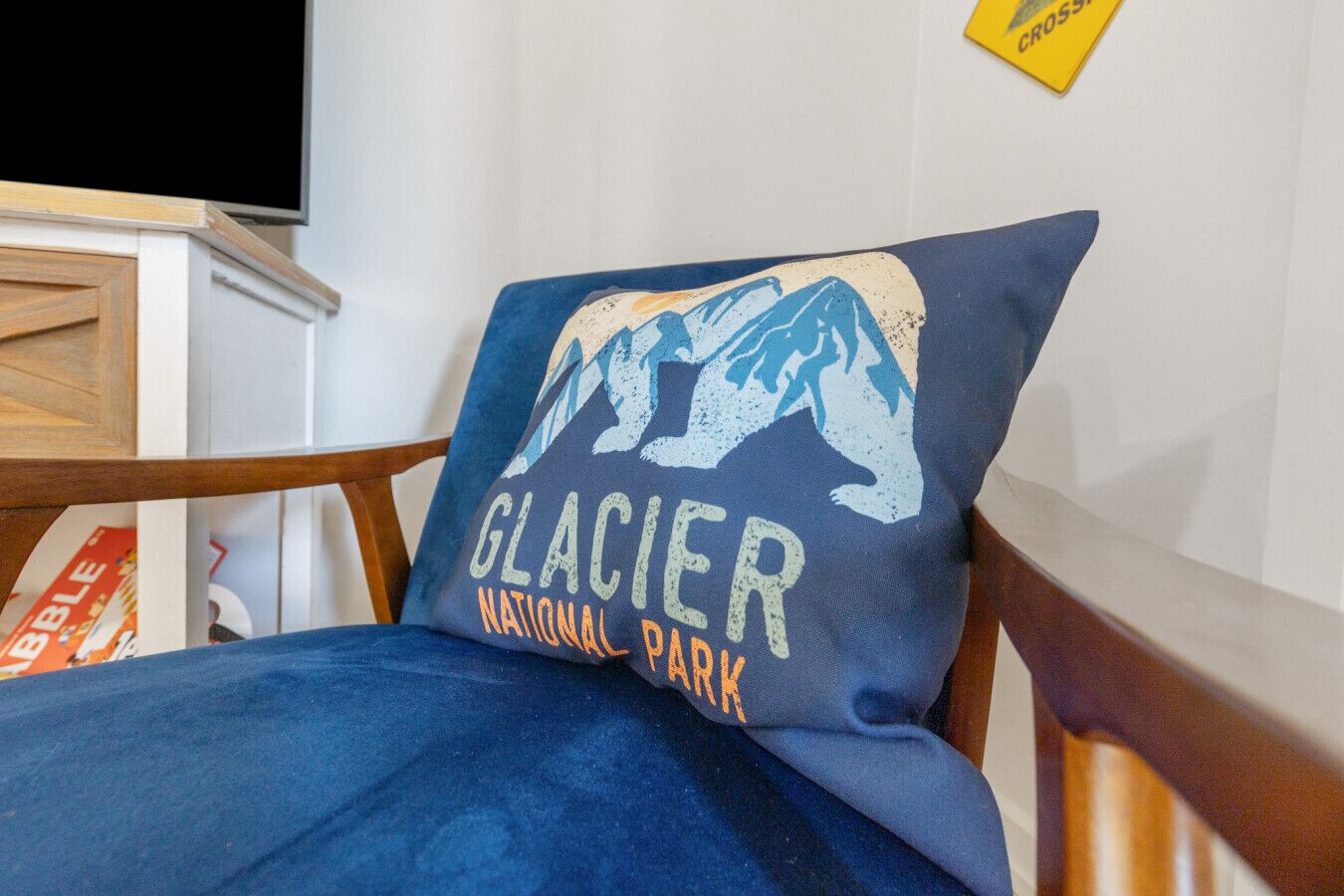 Un letto con un cuscino raffigurante un ghiacciaio e il testo 'Glacier National Park'.