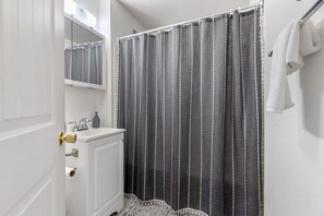 A bathroom with a shower curtain, a sink, a mirror, and a towel rack. - Family Friendly Space w/ Spacious Yard and Firepit (Columbia Falls)