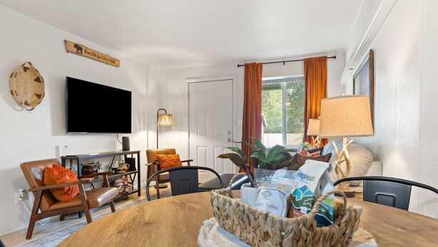 Ein Essbereich mit Holztisch, Stühlen, einem Fernseher und einem Schild mit der Aufschrift Glacier National Park.