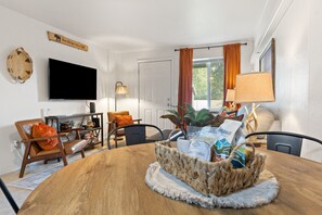 Ein Essbereich mit Holztisch, Stühlen, einem Fernseher und einem Schild mit der Aufschrift Glacier National Park.