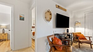 Ein Wohnzimmer mit Fernseher, zwei Ledersesseln, einem Couchtisch und einem Schild mit der Aufschrift Glacier National Park.