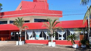 Un bâtiment rouge doté de nombreuses fenêtres et d’un toit plat.