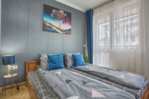 Une chambre à coucher avec un lit, une table de chevet, une lampe et un tableau au mur.
