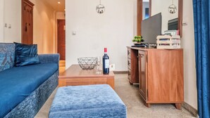 A compact living room with a sofa, a coffee table, a small cabinet, and a mirror. - Charming 1-bedroom hotel suites in wonderful Bansko with WiFi (Bansko)