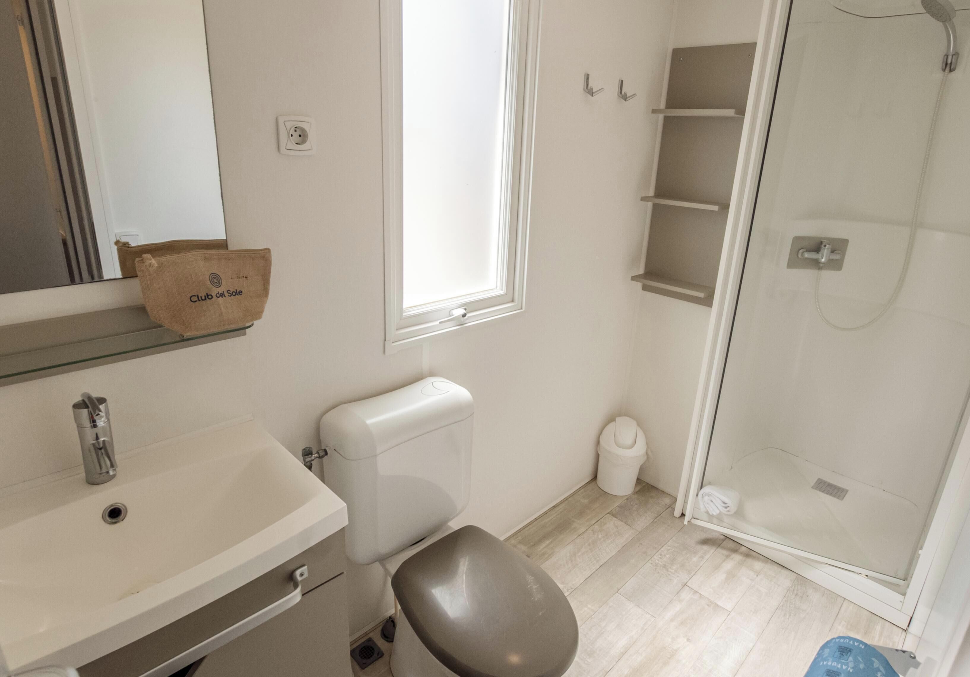 A bathroom with a toilet, sink, and shower.