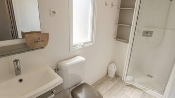 A bathroom with a toilet, sink, and shower.