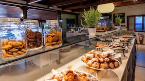A buffet with various pastries and cookies displayed in glass jars and on plates. - Hotiday Lodge Orbetello (Orbetello)
