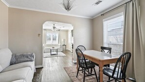 A dining area with a wooden table and chairs, a sofa, and a rug. - Stylish & Modern Private Getaway in Richardson! (Richardson)