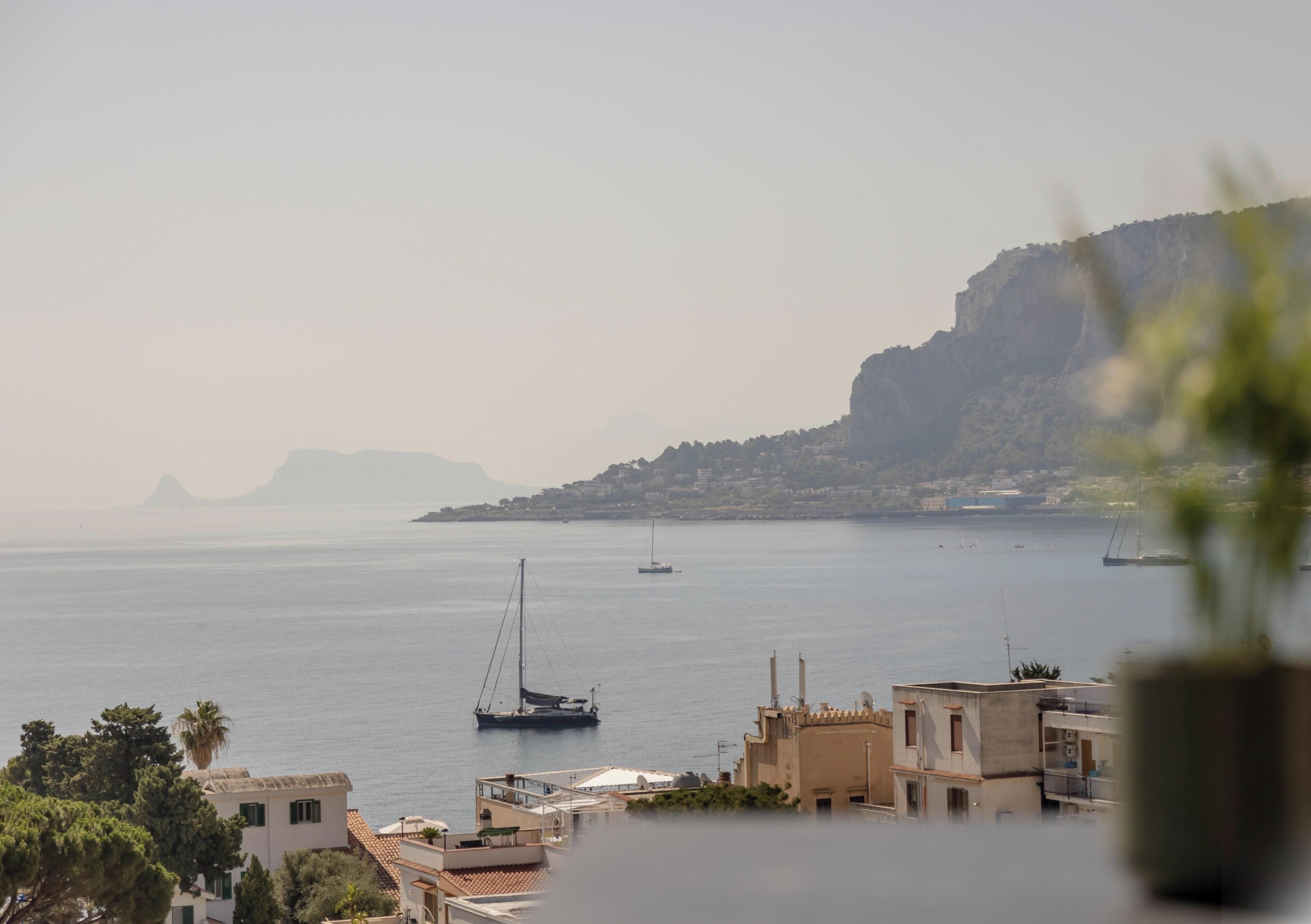 A coastal town with buildings, a large body of water, and boats.