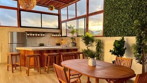 A modern kitchen with a central island, wooden chairs, and a dining table. - Private 3 floors building 8 bedrooms 10 bathrooms for 30 people, Best Location (Playa del Carmen)