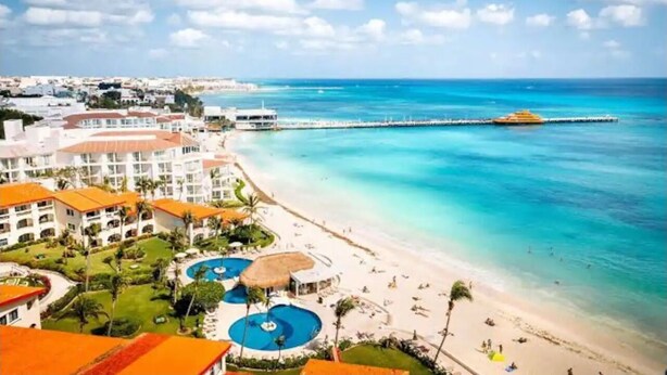A resort with multiple swimming pools, a beach, and a pier extending into the sea. - Private 3 floors building 8 bedrooms 10 bathrooms for 30 people, Best Location (Playa del Carmen)