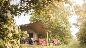 A covered outdoor area with a table and chairs, surrounded by trees. - Fort Vuren (Vuren)
