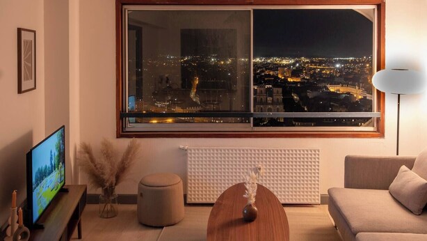 A modern living room with a large window overlooking a cityscape at night. - Breathtaking view - Private garage (Rennes)