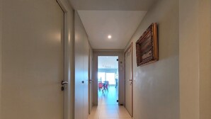 A hallway with white walls and doors, leading to a room with a sign that reads "Dance Love". - Stylish Holiday Apartment in Middelkerke (Middelkerke)