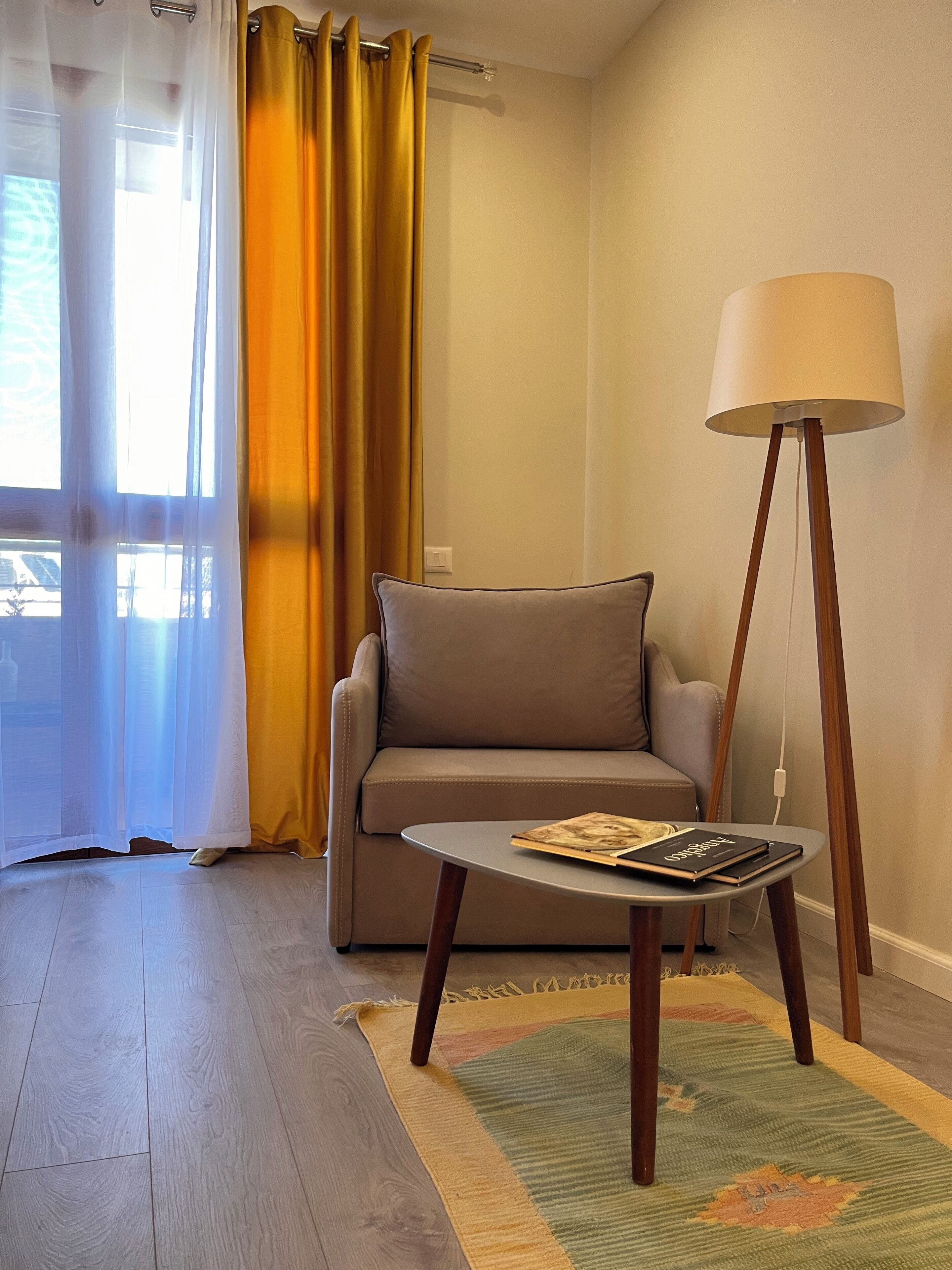 Un salon avec un canapé, une table basse, un lampadaire et un tapis.