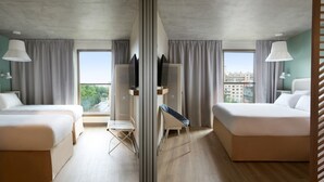 A hotel room with two beds, a TV, a small table, and a window with curtains. - OKKO Hotels Troyes Centre (Troyes)