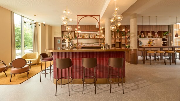 A modern bar area with a central counter, bar stools, and pendant lighting. - OKKO Hotels Troyes Centre (Troyes)